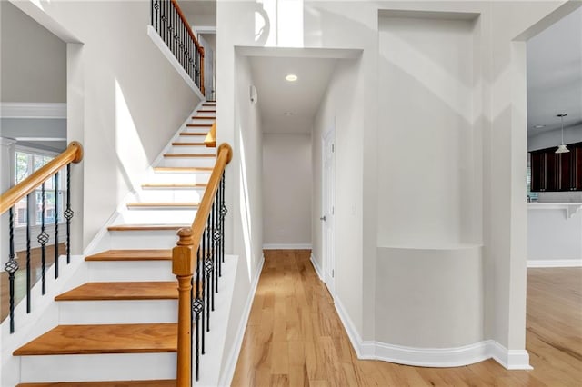 staircase with baseboards and wood finished floors