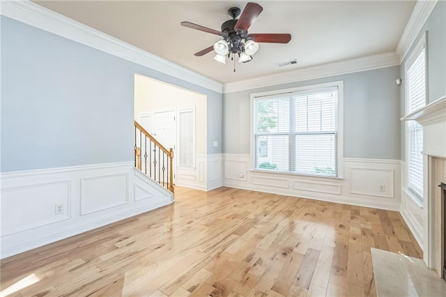 unfurnished living room with light wood-type flooring, plenty of natural light, visible vents, and stairs