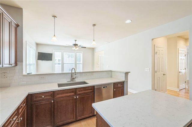 kitchen featuring a ceiling fan, tasteful backsplash, a sink, hanging light fixtures, and dishwasher