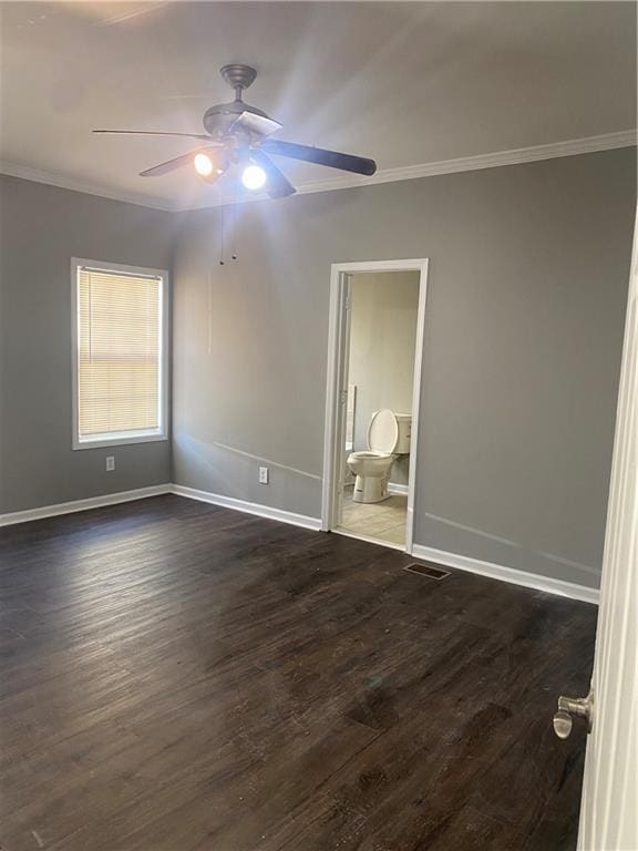 spare room featuring crown molding, ceiling fan, and dark wood-type flooring