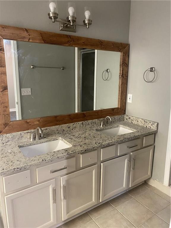 bathroom featuring tile patterned flooring, vanity, and a notable chandelier