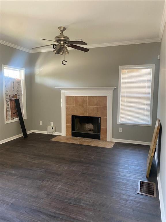 unfurnished living room with dark hardwood / wood-style flooring, ceiling fan, crown molding, and a tiled fireplace