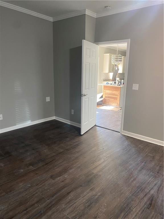 spare room with dark hardwood / wood-style flooring and ornamental molding