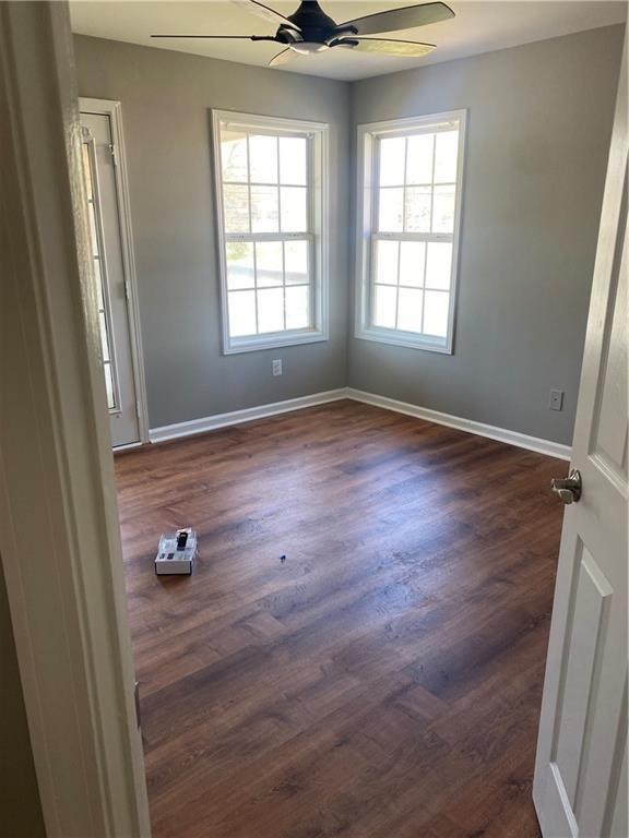 empty room with ceiling fan and dark hardwood / wood-style floors