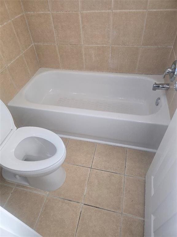 bathroom with toilet, shower / tub combination, and tile patterned floors