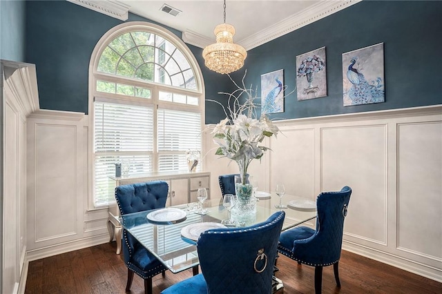 dining room featuring an inviting chandelier, ornamental molding, a healthy amount of sunlight, and dark hardwood / wood-style floors