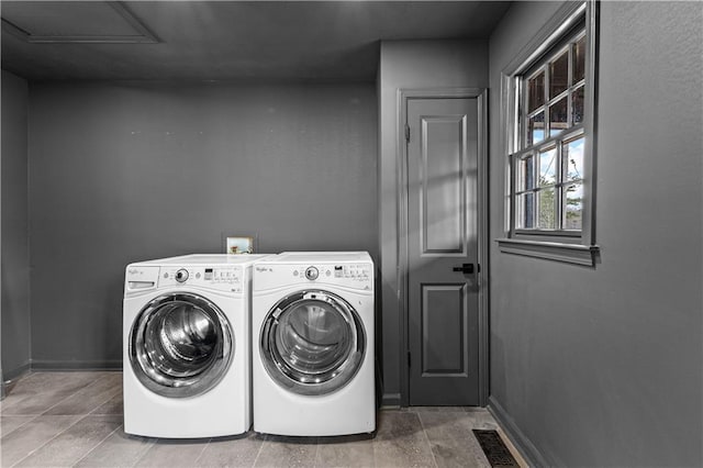 clothes washing area with laundry area, washing machine and dryer, and baseboards