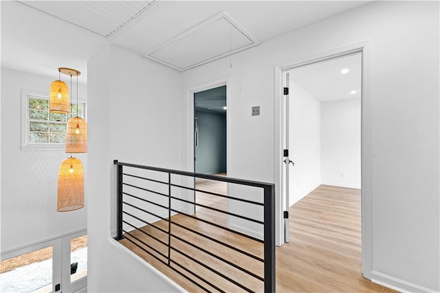 hall featuring attic access, baseboards, wood finished floors, an upstairs landing, and recessed lighting