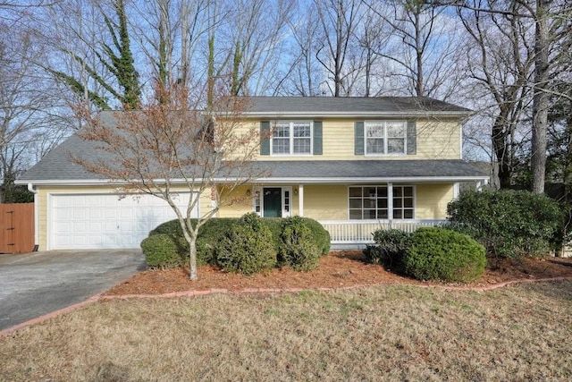 view of property featuring a garage and a front lawn