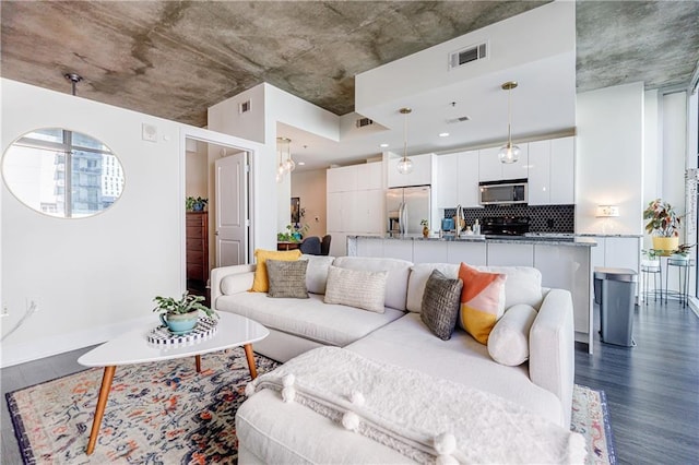 living area with dark wood-style floors and visible vents