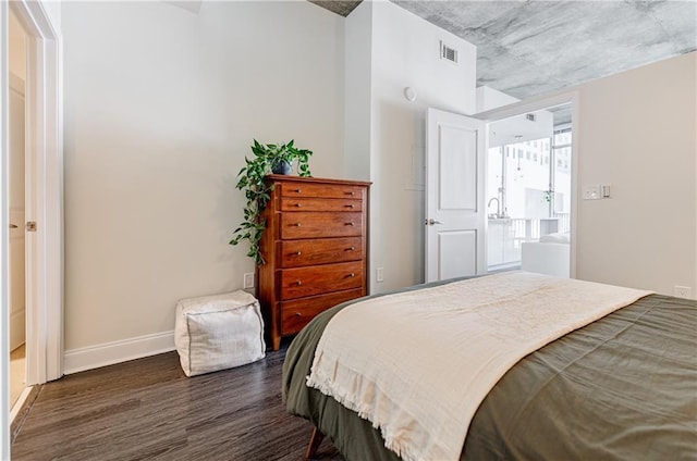 bedroom with dark wood-type flooring, visible vents, and baseboards