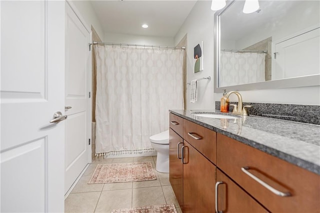 bathroom featuring tile patterned flooring, vanity, and toilet