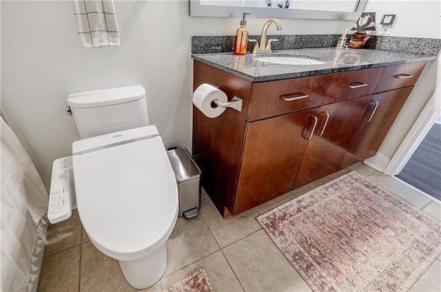 bathroom with toilet, tile patterned floors, and vanity