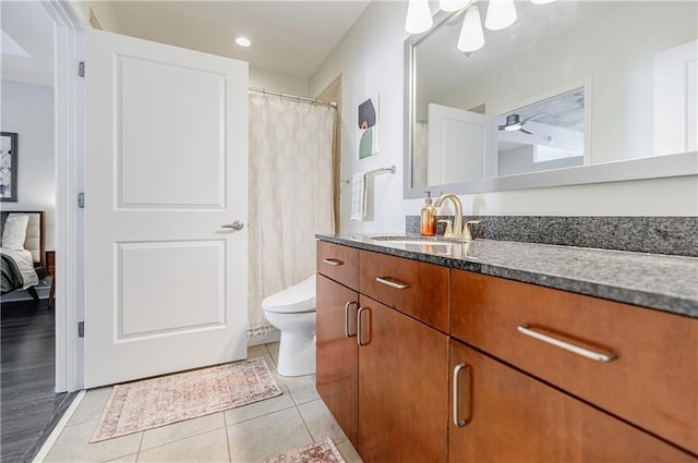 full bath featuring toilet, vanity, and tile patterned floors