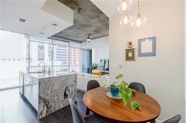 dining area with dark wood-style floors, ceiling fan, floor to ceiling windows, and visible vents