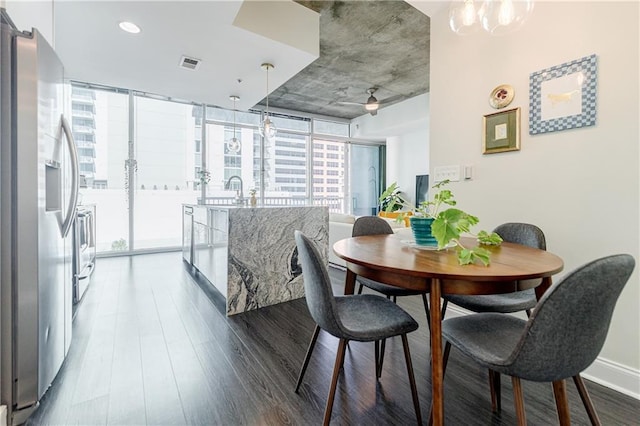 dining room featuring baseboards, expansive windows, visible vents, and dark wood-type flooring