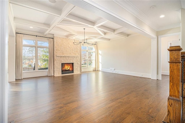 unfurnished living room featuring beam ceiling, dark wood-type flooring, coffered ceiling, an inviting chandelier, and a fireplace