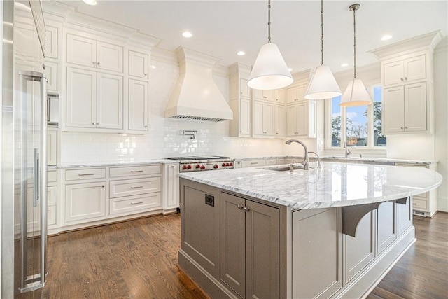 kitchen with custom exhaust hood, a kitchen island with sink, dark wood-type flooring, sink, and white cabinetry