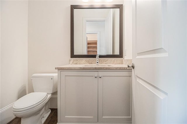 bathroom with vanity, toilet, and wood-type flooring