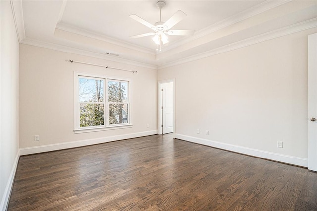 empty room with dark hardwood / wood-style flooring, a tray ceiling, ceiling fan, and crown molding