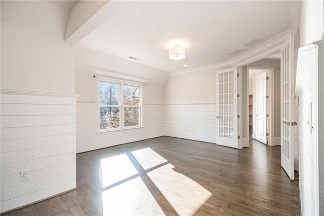 spare room featuring dark hardwood / wood-style flooring, ornamental molding, and wood walls