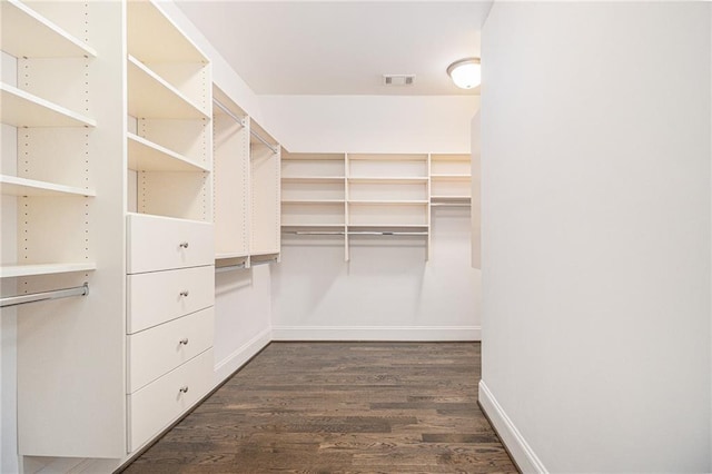 walk in closet with dark wood-type flooring