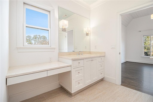 bathroom with vanity, vaulted ceiling, and ornamental molding