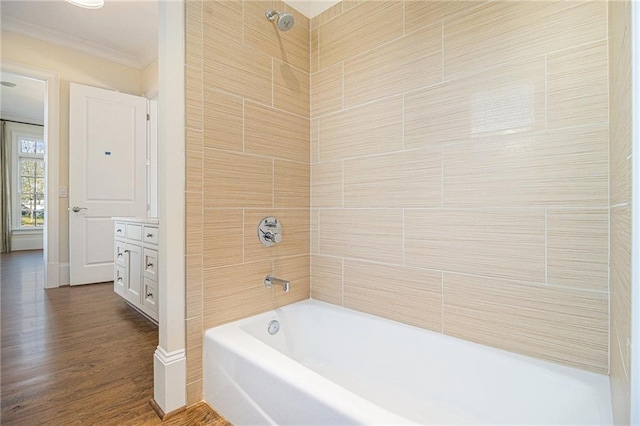 bathroom with hardwood / wood-style floors, vanity, tiled shower / bath, and crown molding