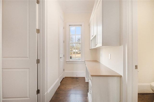 hall with dark hardwood / wood-style floors and ornamental molding