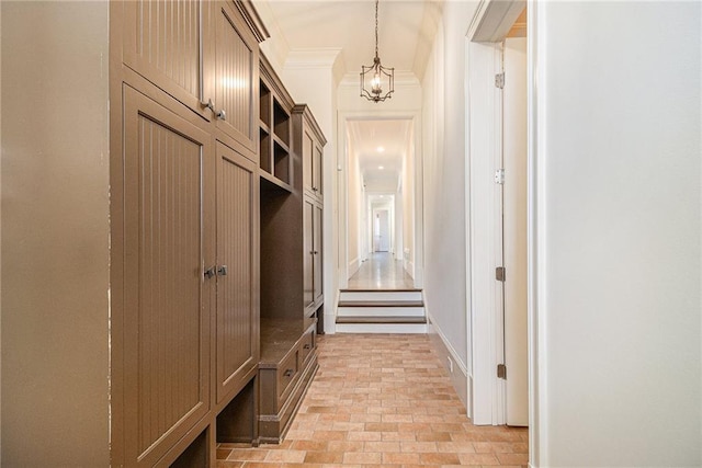 mudroom with a notable chandelier and crown molding