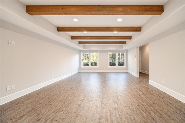 spare room featuring beam ceiling and hardwood / wood-style flooring