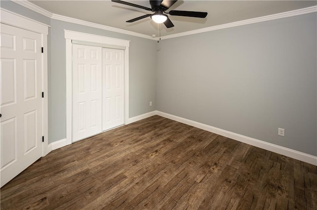unfurnished bedroom featuring a closet, baseboards, ornamental molding, and dark wood-type flooring