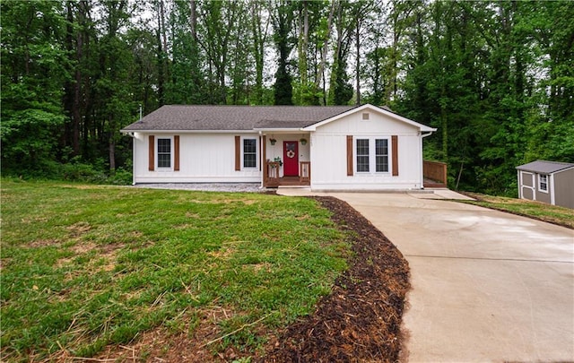 ranch-style house with an outbuilding, concrete driveway, a shed, and a front yard