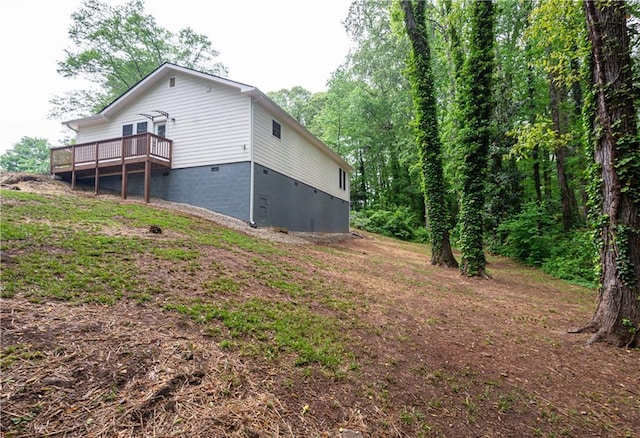 rear view of house with a wooden deck and crawl space
