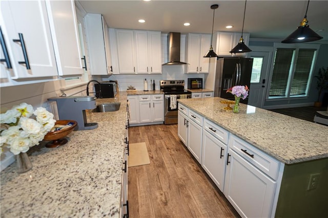 kitchen with wall chimney range hood, electric range, a sink, white cabinets, and black fridge