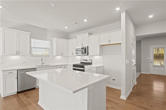 488 Village Ln, Fairburn, GA 30213 - kitchen with appliances with stainless steel finishes, a sink, light wood finished floors, backsplash, and recessed lighting