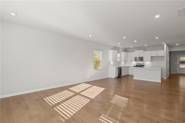 488 Village Ln, Fairburn, GA 30213 - unfurnished living room with a sink, baseboards, wood finished floors, and recessed lighting