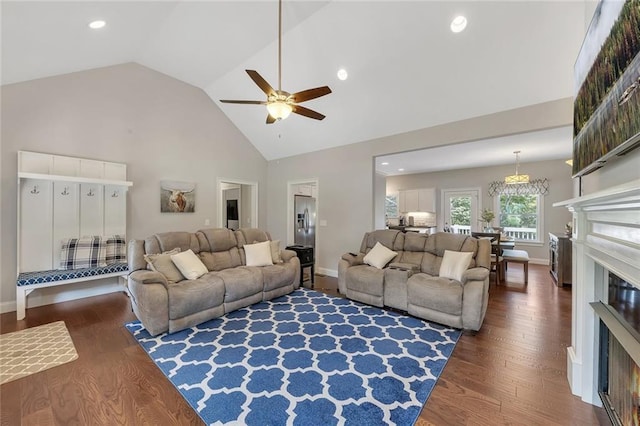 living room with ceiling fan, dark hardwood / wood-style floors, and high vaulted ceiling