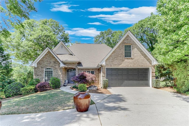 view of front of property with a front lawn, driveway, stone siding, and a garage