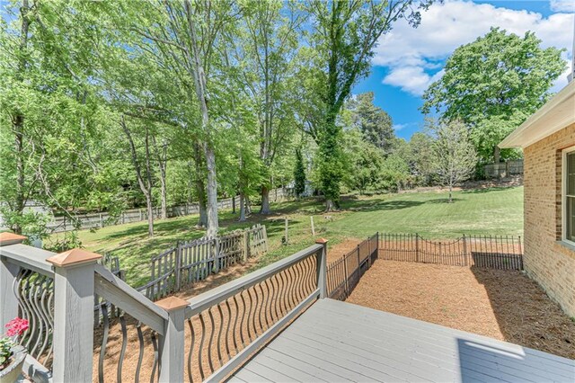 deck with a lawn and a fenced backyard
