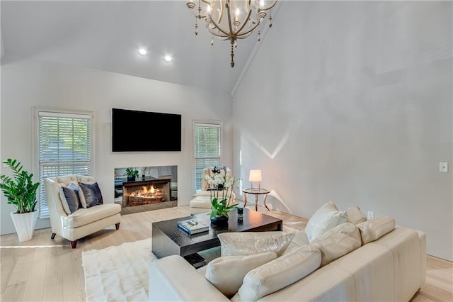 living area featuring lofted ceiling, light wood-style floors, a high end fireplace, and a healthy amount of sunlight