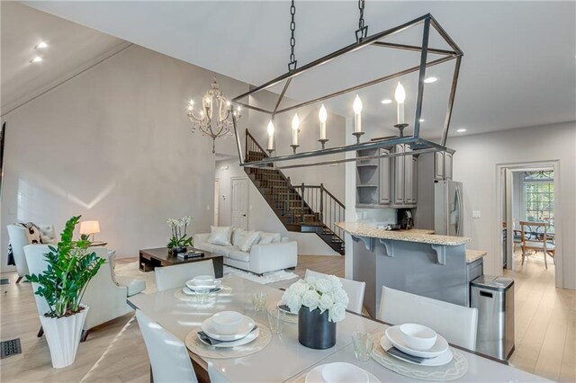 dining area with light wood finished floors, visible vents, recessed lighting, a chandelier, and stairway