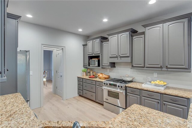 kitchen featuring stainless steel appliances, light wood-type flooring, recessed lighting, light stone counters, and gray cabinets