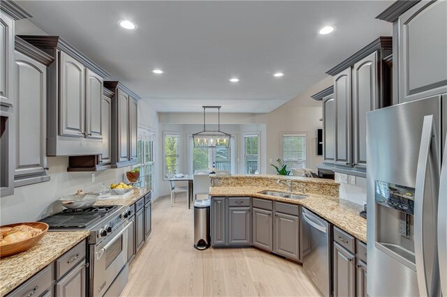 kitchen featuring light wood finished floors, a peninsula, recessed lighting, and appliances with stainless steel finishes