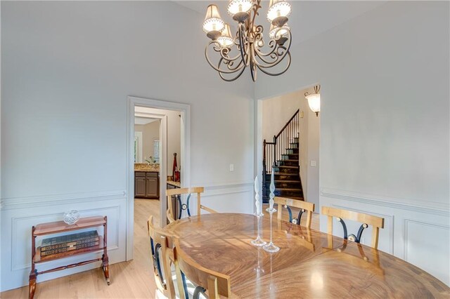 dining area with a chandelier, stairs, and light wood-type flooring