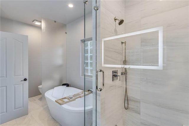 full bathroom with a shower stall, toilet, and a freestanding tub