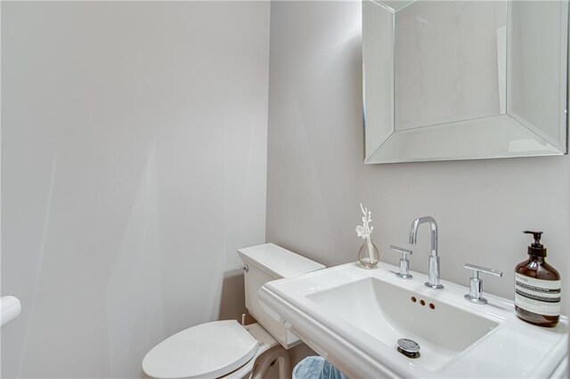 half bathroom featuring toilet and a sink