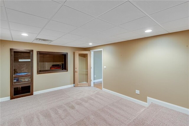 spare room featuring recessed lighting, carpet, a drop ceiling, and baseboards