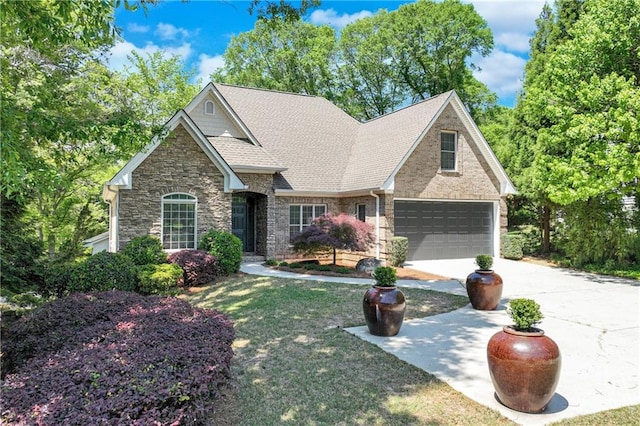 craftsman-style house featuring roof with shingles, stone siding, concrete driveway, a garage, and a front yard