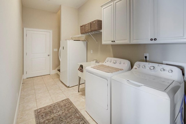 clothes washing area featuring cabinets, light tile patterned flooring, washing machine and dryer, and sink